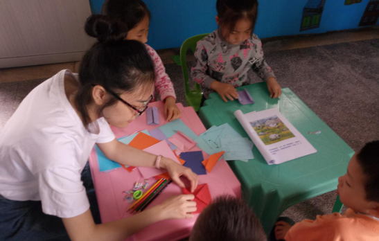 志愿者教孩子们折纸